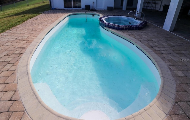 view of pool with an in ground hot tub and a patio area