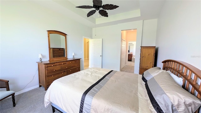 carpeted bedroom with ensuite bath and ceiling fan