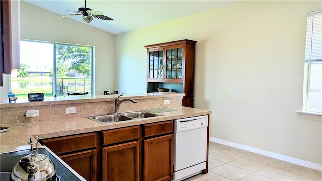 kitchen with light tile patterned flooring, sink, white dishwasher, ceiling fan, and vaulted ceiling