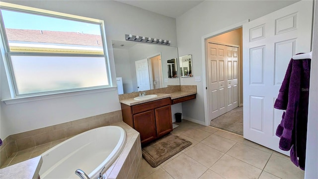 bathroom featuring vanity, tiled tub, and tile patterned flooring