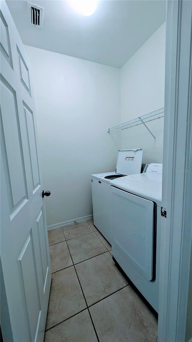 laundry area featuring washer and dryer and light tile patterned flooring