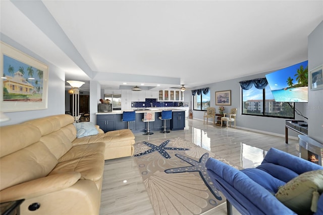 living room with ceiling fan and light hardwood / wood-style flooring