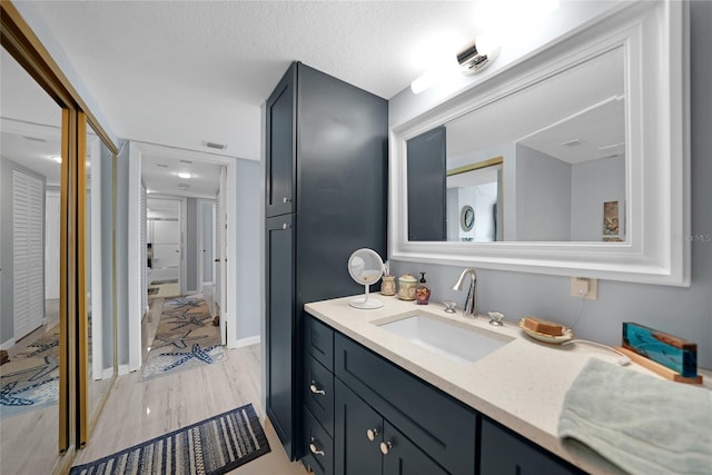 bathroom featuring vanity, a textured ceiling, and wood-type flooring