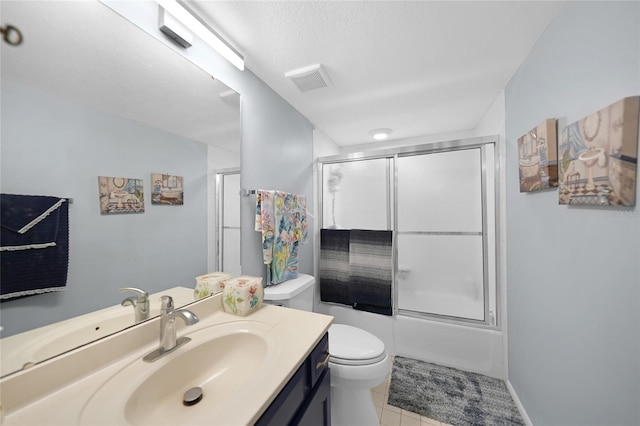 full bathroom featuring vanity, bath / shower combo with glass door, toilet, and tile patterned flooring