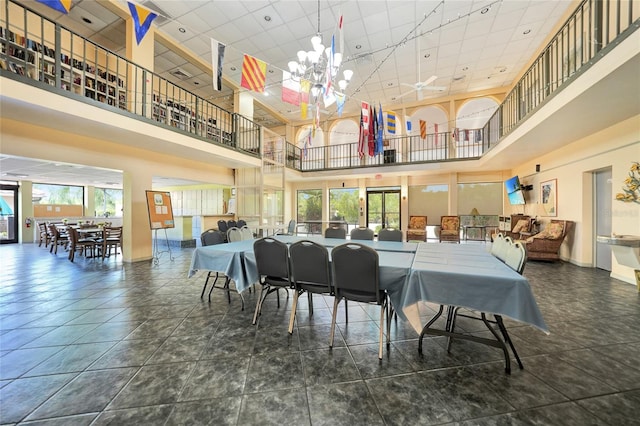 tiled dining area featuring a high ceiling and a notable chandelier