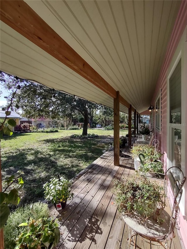 wooden terrace featuring a yard