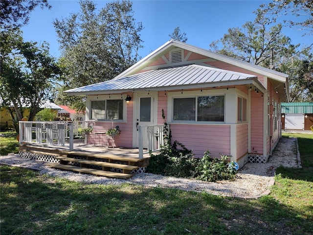 bungalow featuring a front yard and a deck