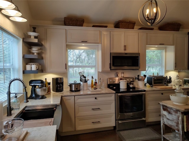 kitchen featuring white cabinetry, appliances with stainless steel finishes, sink, and pendant lighting