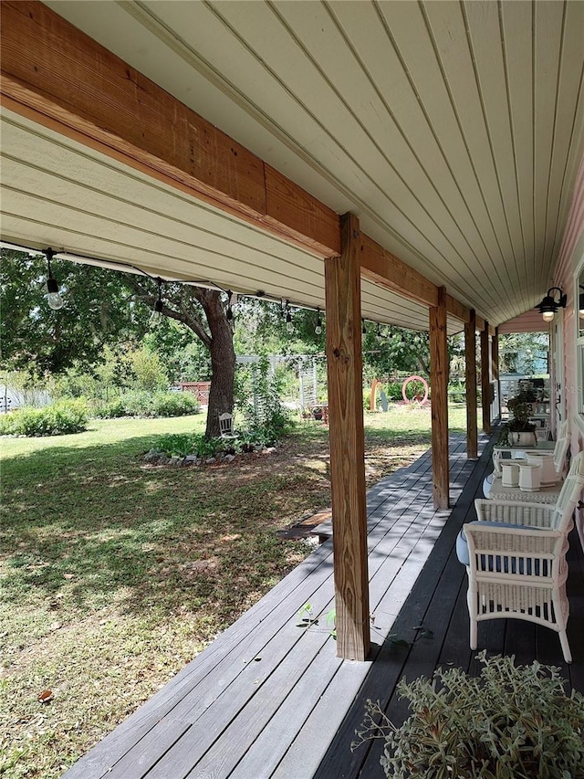 wooden deck featuring a lawn