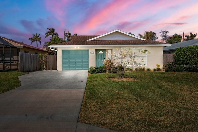 ranch-style home featuring a lawn and a garage