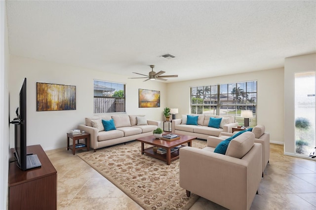 living room featuring a textured ceiling and ceiling fan