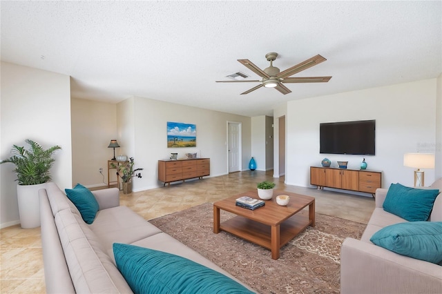 living room featuring a textured ceiling and ceiling fan