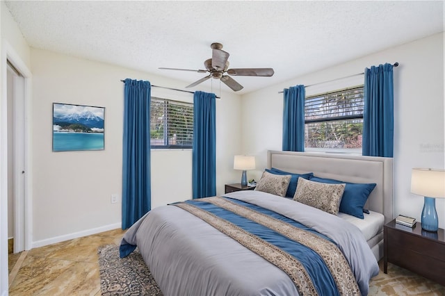 bedroom featuring multiple windows, a textured ceiling, and ceiling fan