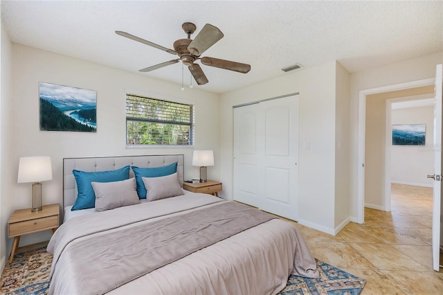 bedroom featuring a closet, a textured ceiling, and ceiling fan