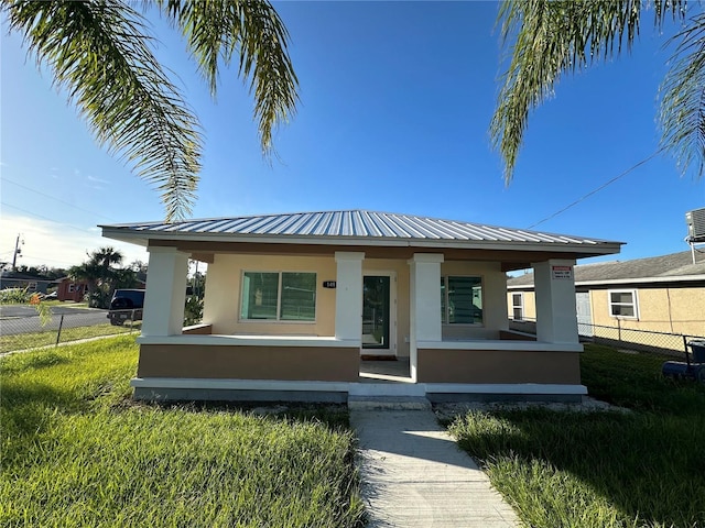 view of front of house featuring covered porch and a front yard