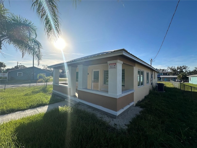 view of home's exterior featuring central air condition unit and a yard