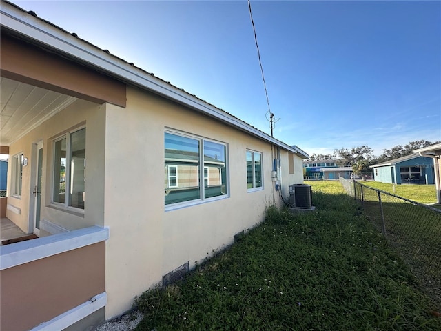 view of home's exterior with a yard and cooling unit