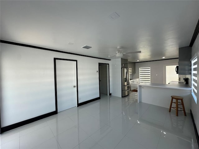 interior space featuring ceiling fan, ornamental molding, and light tile patterned flooring