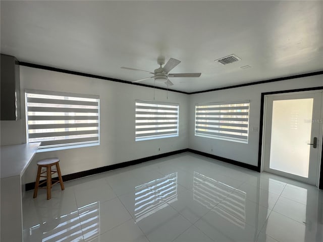 spare room with ceiling fan, light tile patterned flooring, and crown molding