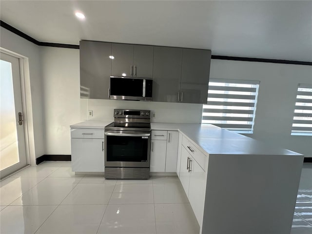 kitchen with kitchen peninsula, light tile patterned floors, stainless steel appliances, and crown molding