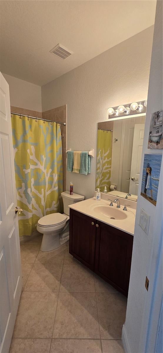 bathroom with vanity, toilet, tile patterned floors, and curtained shower