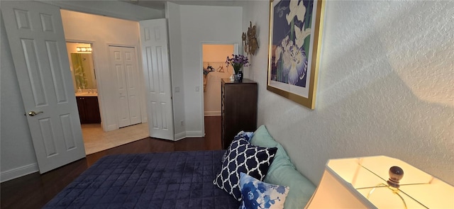 bedroom featuring dark hardwood / wood-style floors, a closet, and ensuite bath