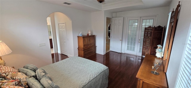 bedroom with access to outside, french doors, a tray ceiling, and dark hardwood / wood-style flooring