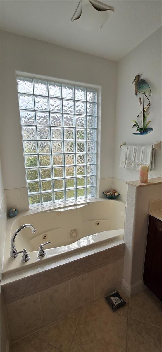 bathroom with vanity, plenty of natural light, and tiled tub