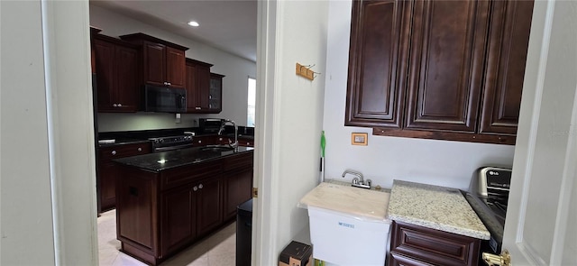 kitchen with stainless steel range with electric cooktop, light stone countertops, light tile patterned flooring, dark brown cabinetry, and sink