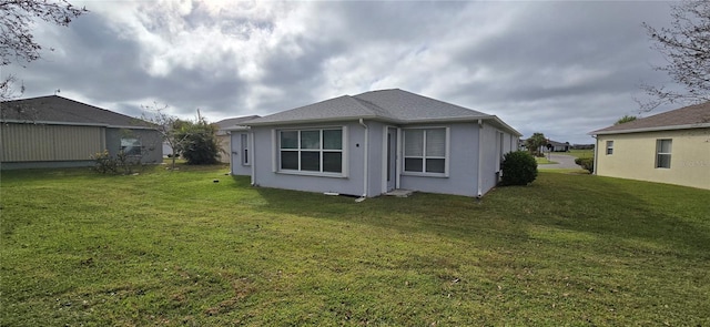 back of house with a lawn