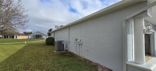 view of side of property with cooling unit and a lawn