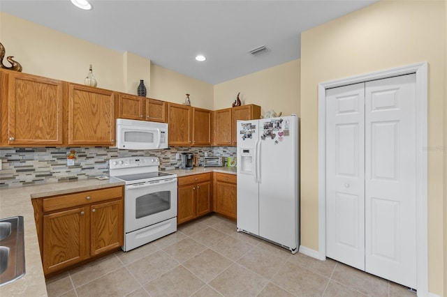 kitchen featuring white appliances, backsplash, and light tile patterned flooring