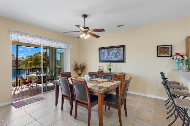 tiled dining space with ceiling fan