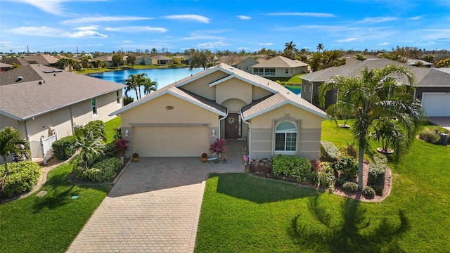 ranch-style home with a garage, a front lawn, and a water view