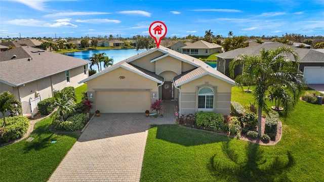 view of front of home featuring a front yard, a garage, and a water view