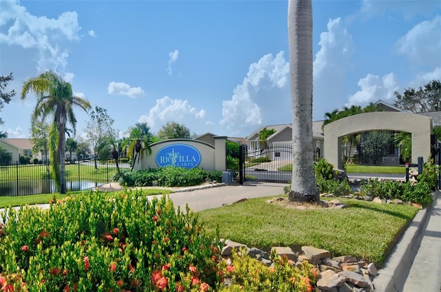 community sign featuring a water view and a lawn