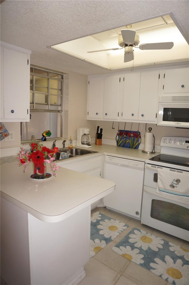 kitchen with kitchen peninsula, light tile patterned floors, white cabinets, white appliances, and ceiling fan