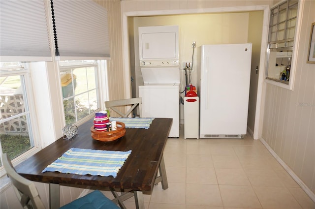 tiled dining room with stacked washer and dryer