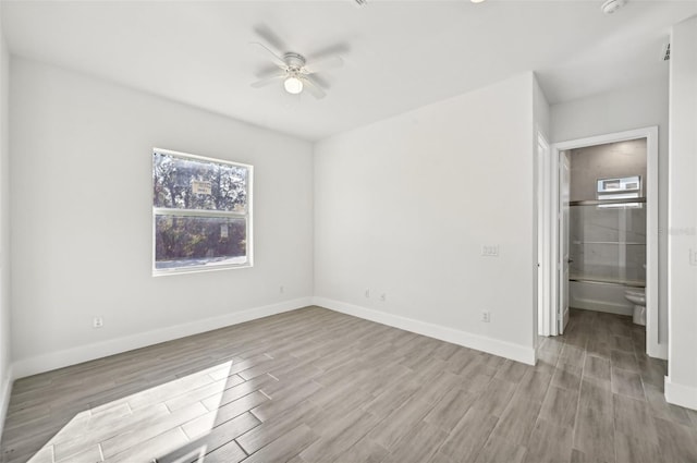 unfurnished bedroom featuring connected bathroom, light hardwood / wood-style flooring, and ceiling fan