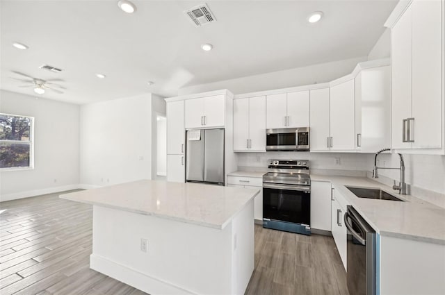 kitchen featuring appliances with stainless steel finishes, white cabinets, and sink