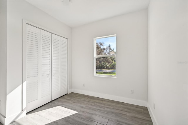 unfurnished bedroom with light hardwood / wood-style flooring and a closet