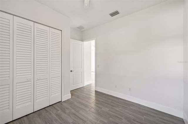 unfurnished bedroom featuring hardwood / wood-style flooring and a closet