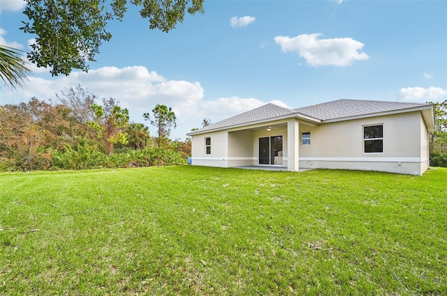 rear view of property featuring a yard and a patio