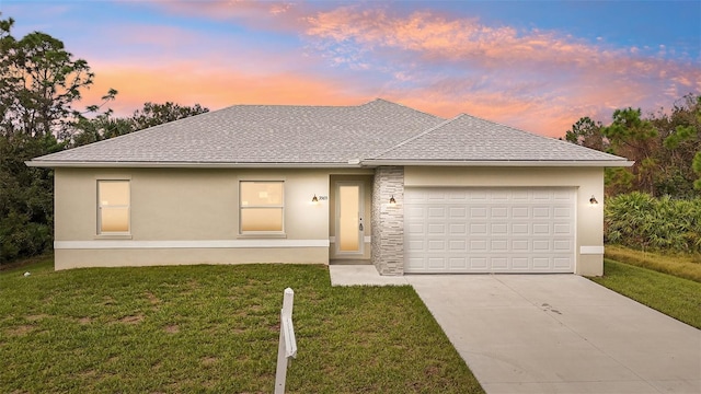 view of front of property featuring a garage and a lawn