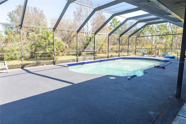 view of pool with glass enclosure and a patio area