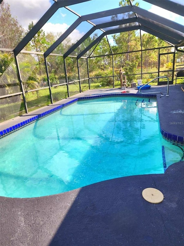 view of pool with glass enclosure