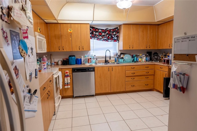 kitchen with sink, light tile patterned flooring, and white appliances