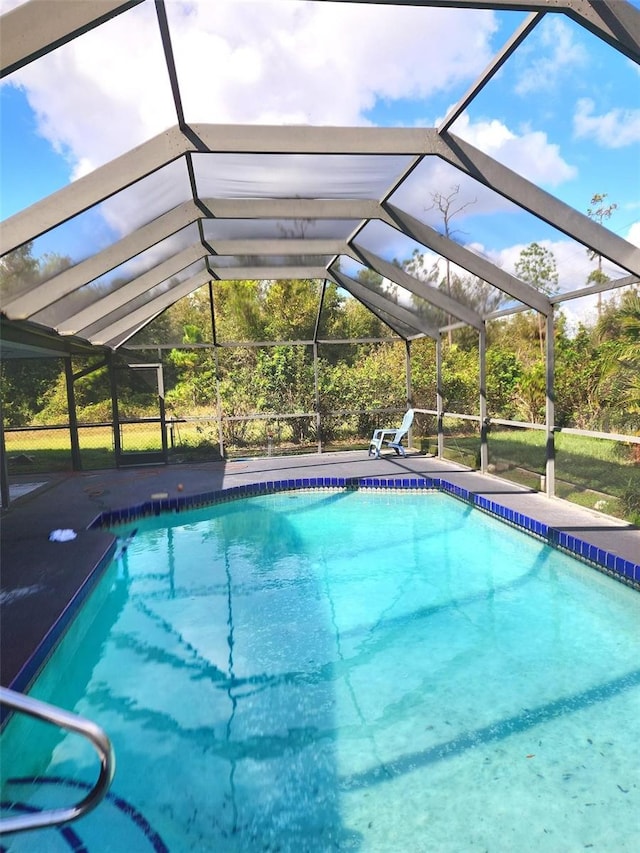 view of swimming pool with glass enclosure