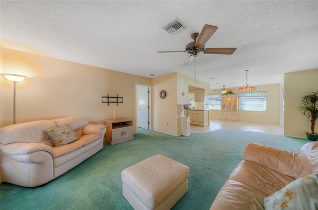 living room with light carpet, a textured ceiling, and ceiling fan