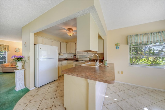 kitchen with sink, kitchen peninsula, a textured ceiling, and white appliances